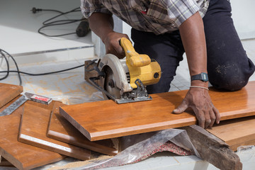 carpenter use electric saw to sawing wood