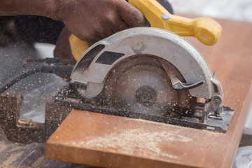 carpenter use electric saw to sawing wood