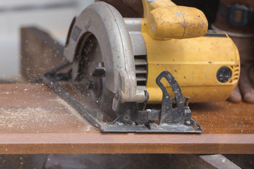 carpenter use electric saw to sawing wood