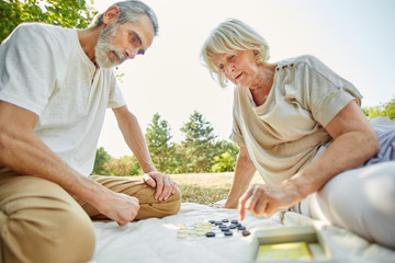 Senioren Paar spielt das Brettspiel Mühle
