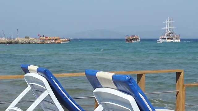 View of Turkish Gulet cruise boats taking tourists out on the Aegean Sea for the day, focus is on the sun loungers