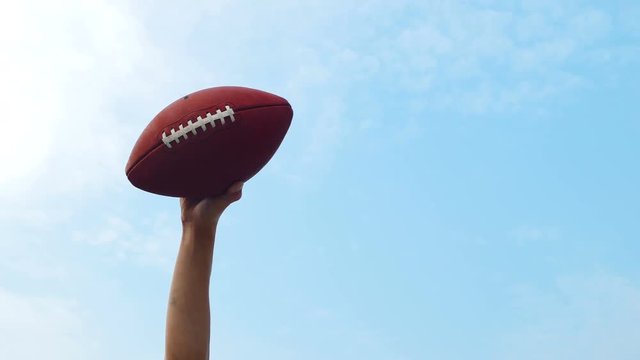 Tailgate: Man Holds Up Football Against Sky