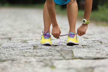 tired woman runner taking a rest after running hard on forest trail