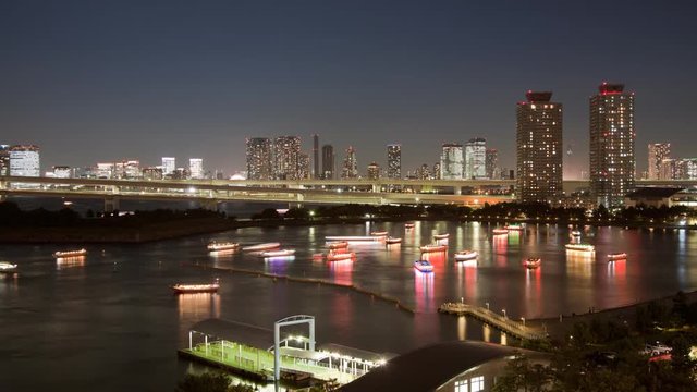Night time-lapse of dinner cruise boats in Tokyo Bay near Odaiba. Shot with a tilt-shift lens. Tokyo Japan.