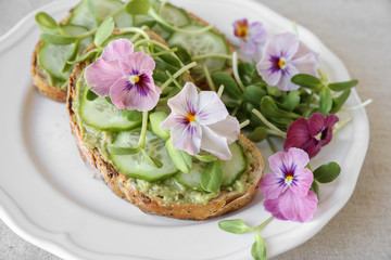 avocado , cucumber, sunflower sprout and edible flowers on sourd