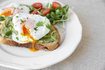 Poached eggs with avocado,tomato and sunflower sprout on sourdou