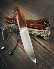 hunting knife handmade on a wooden background