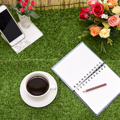 Writing on copy space note book on green grass Background.With s