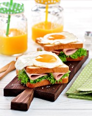 Sandwich with ham, lettuce and a fried egg. Breakfast.