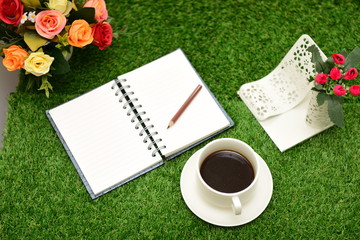 Writing on copy space note book on green grass Background.With s