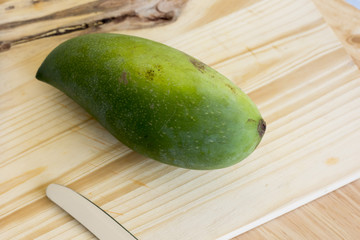 Whole Green Mango on a wooden table.In selective focus.