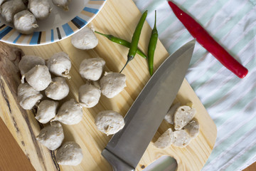Meat ball on a wooden cutting board and knife.In selective focus