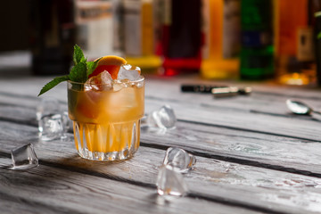 Glass with orange drink. Grapefruit slice and mint. Exotic beverage served at club. Cobas cocktail with citrus fruit.