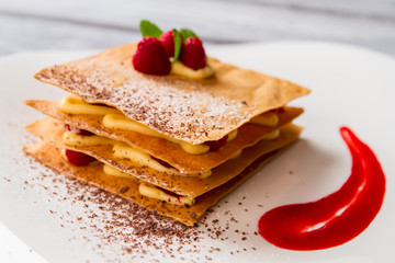 Dessert with chocolate crumbs. Red sauce and custard. Raspberry millefeuille ordered in cafe. Best recipe of french pastry.