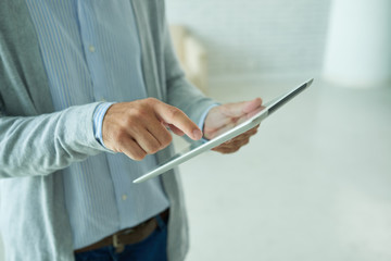 Hands of person using digital tablet in office