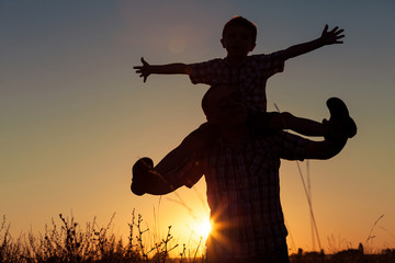 Fototapeta premium Father and son playing at the park at the sunset time.