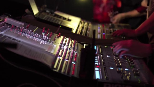 Male and woman hands using a two sound digital mixer at a concert