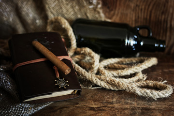 Cigar and leather notebook on a wooden background
