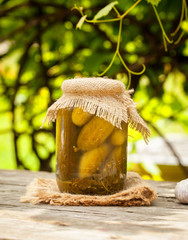 Jar of pickles on wooden table. Salted Cucumbers still-life.