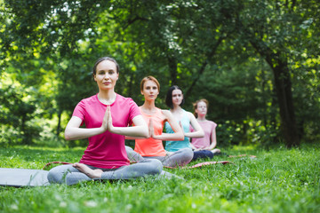 Young women doing yoga in the park.