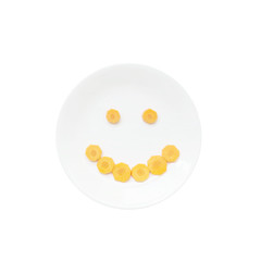 Smile face emotion by cut fresh carrot on ceramic circle dish is