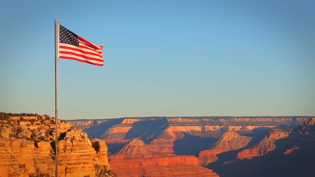 A beautiful morning shot of the Grand Canyon with the US flag blowing in the breeze.