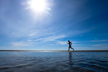 silhouette of man running on the beach