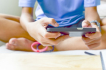 Fototapeta premium Blurry of teenage male hands play with phone at home.