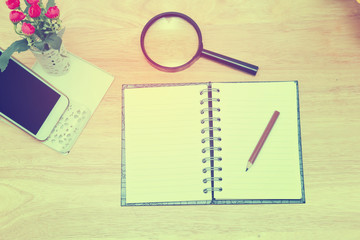 Open Blank notebook and pencil with magnifying glasses and