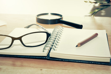 Fototapeta premium Open Blank notebook and pencil with magnifying glasses and