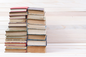 Stack of hardback books on wooden table. Back to school. Copy space
