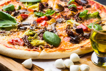 Fresh pizza served on wooden table. Shallow depth of field.