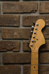 Gitara na tle z cegły.