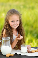 cute little girl eating chocolate chip cookie on green background