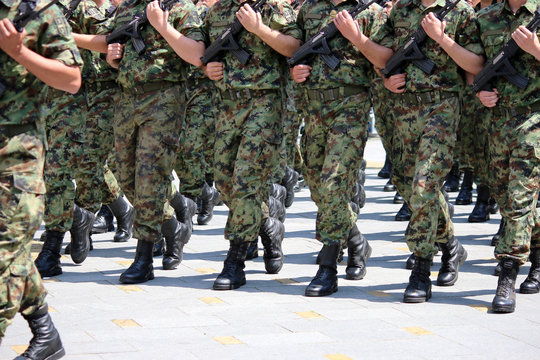 Soldiers with camouflage uniforms marching with rifles