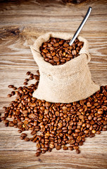 The sack of coffee beans on wooden background