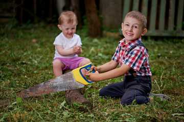 boy sawing fallen tree in garden