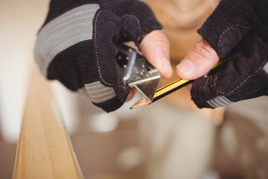 Carpenter's hands sharpening a pencil 