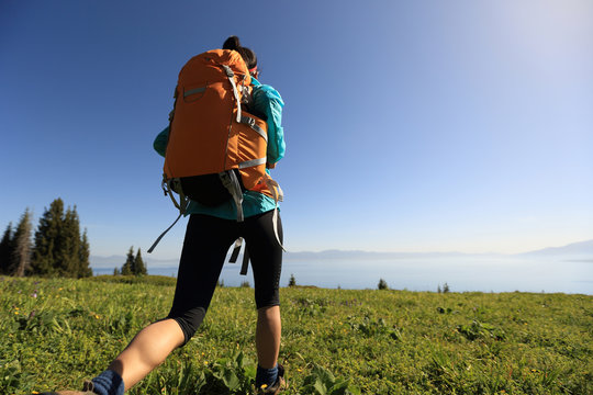 young woman backpacker hiking on beautiful mountain peak
