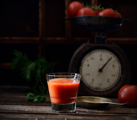 Fresh organic tomato juice on a wooden background