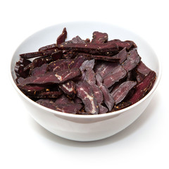 South African beef biltong , dried beef jerky isolated on a white studio background.