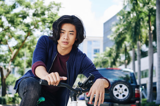 Portrait Of Attractive Asian Man On A Bicycle