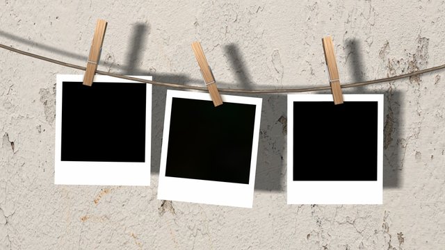three blank instant photos hanging on the clothesline  