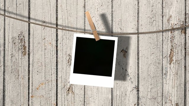 one blank instant photo hanging on the clothesline 