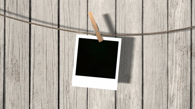 one blank instant photo hanging on the clothesline 