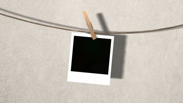 one blank instant photo hanging on the clothesline 