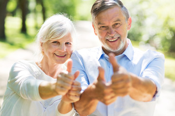 Senior couple showing thumbs up
