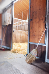 Broom outside an open horse stall