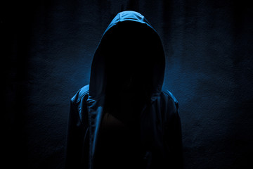 Woman wearing hoodie hiding in the dark,Scary background for book cover