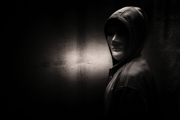 A stranger woman wearing hoodie with white mask hiding in the dark,Scary background for book cover - obrazy, fototapety, plakaty